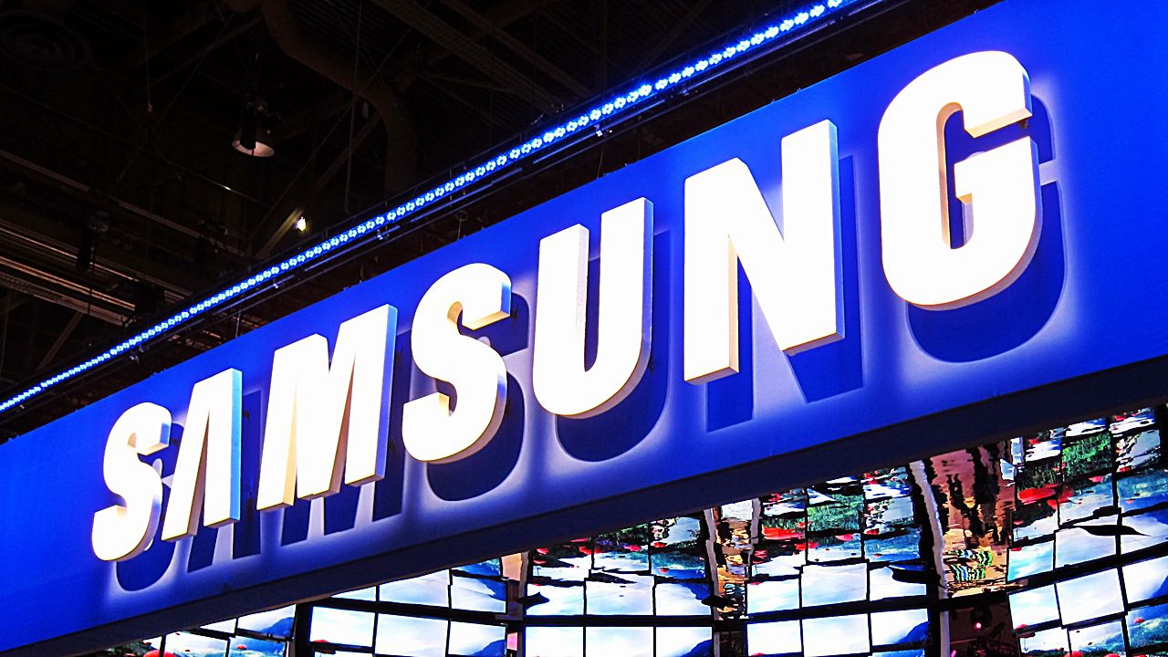 Insegna luminosa Samsung alla fiera tech, simbolo dell’impero multisettore.