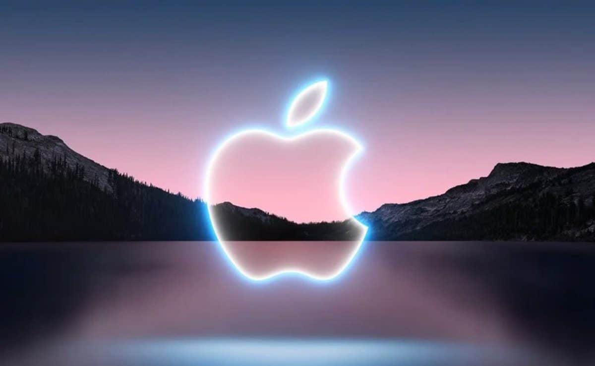 Alt text (in Italian): Logo Apple luminoso su sfondo montano al tramonto, simbolo di innovazione.