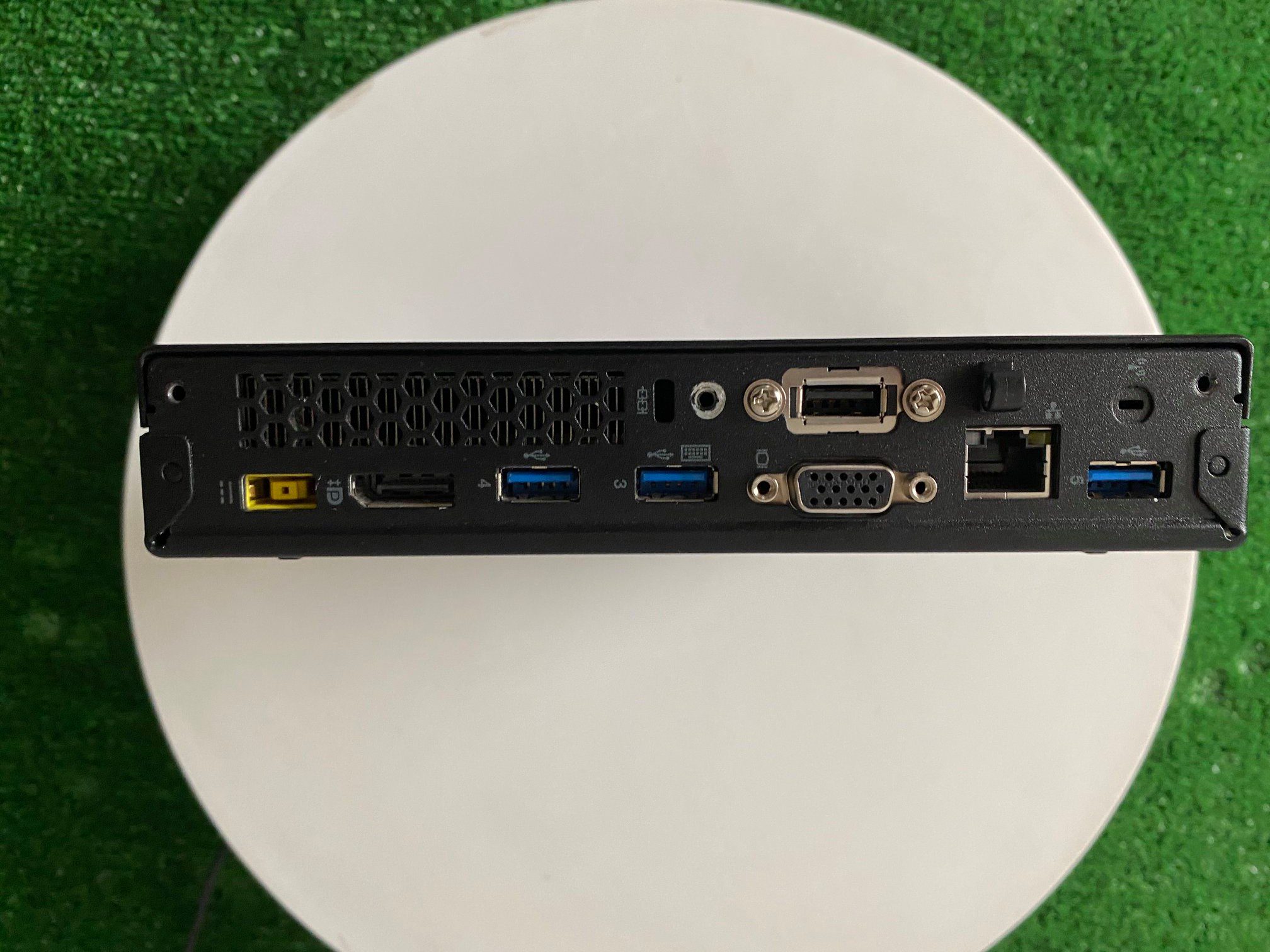 Retro di mini PC ricondizionato con porte USB, VGA, DisplayPort e Ethernet su sfondo verde, Messoanuovo.it