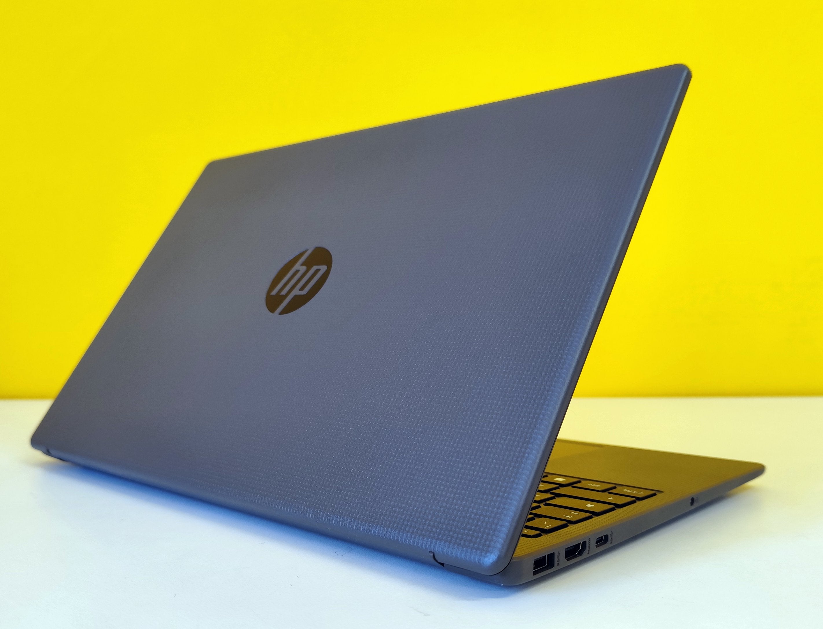 Notebook HP 250 G10 semiaperto con finitura grigia e porte laterali visibili, design moderno e resistente.
