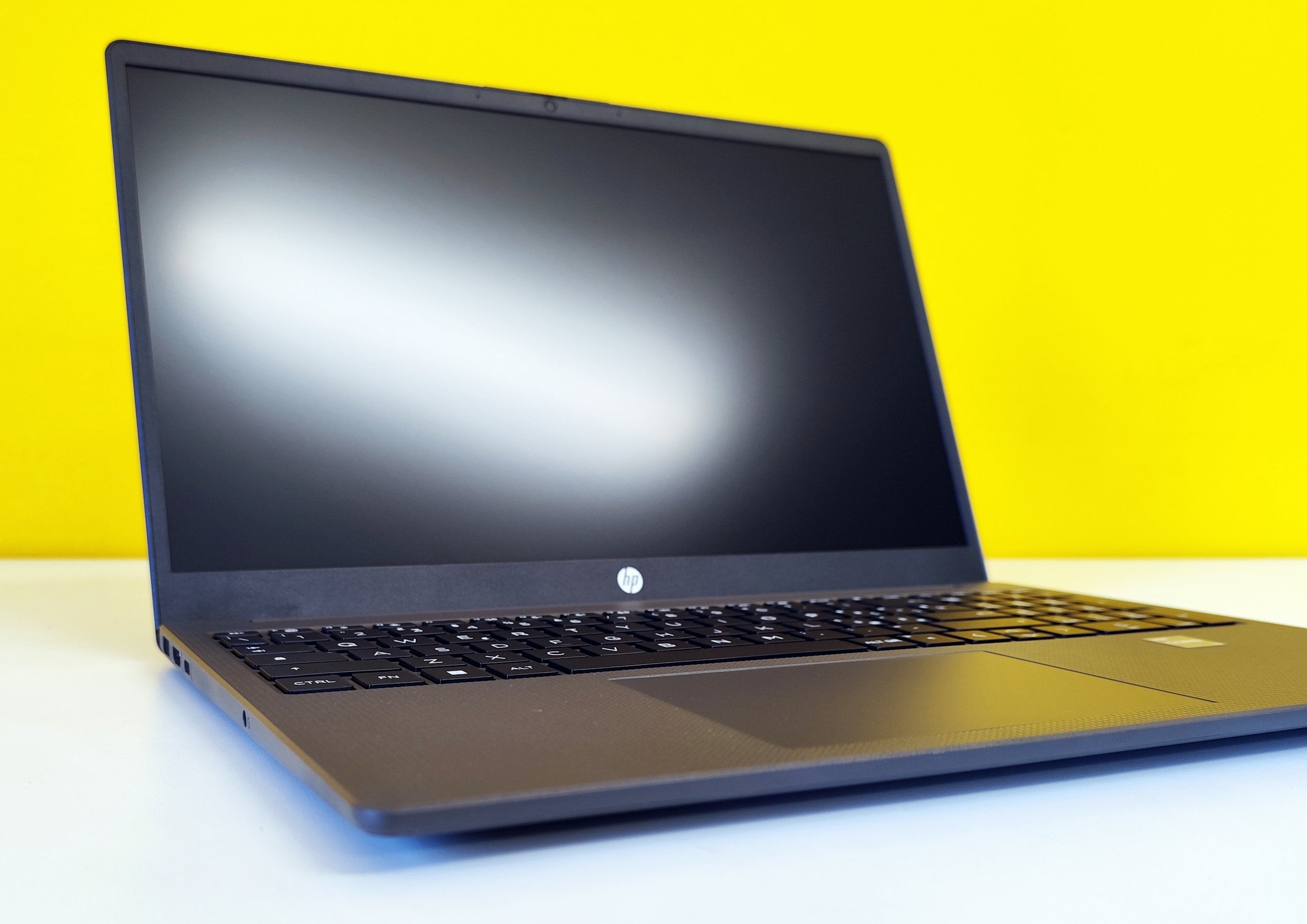 Notebook HP 250 G10 aperto con schermo spento, tastiera visibile e design elegante su sfondo giallo.