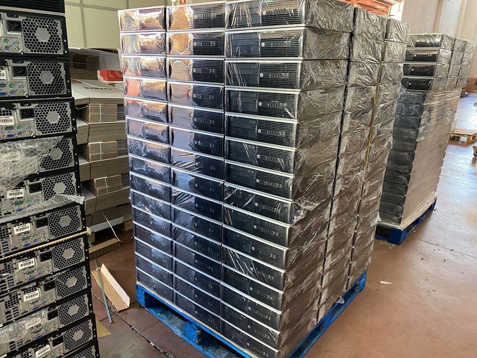 Pallet di pc desktop ricondizionati impilati in magazzino Messoanuovo.it pronti per la vendita.