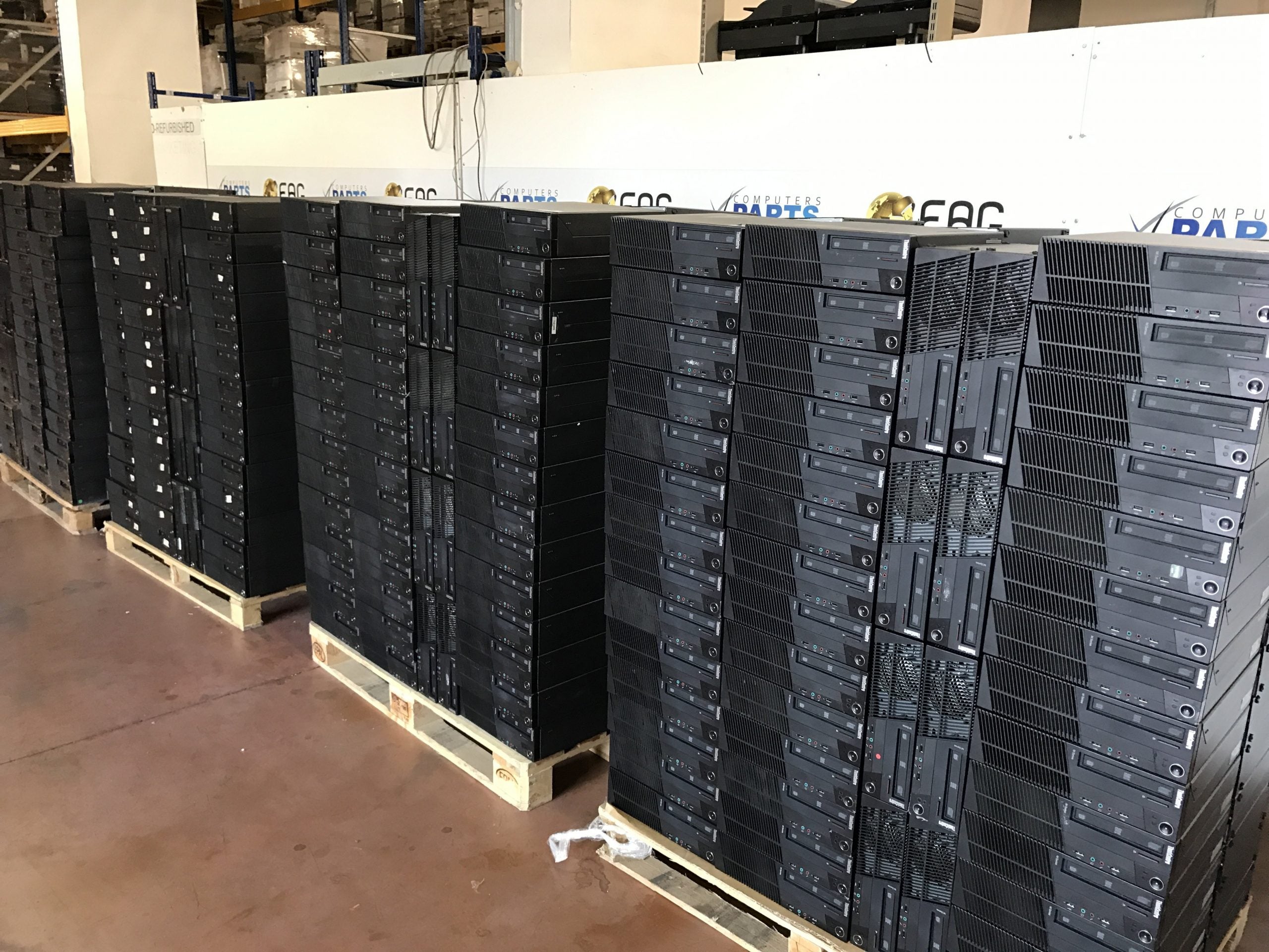 Pc desktop ricondizionati impilati su pallet in magazzino Messoanuovo.it